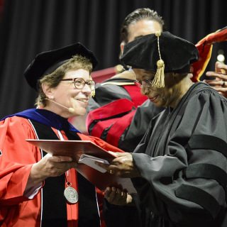 Chancellor Rebecca Blank presents an honorary degree to sociologist Cora Marrett (right).