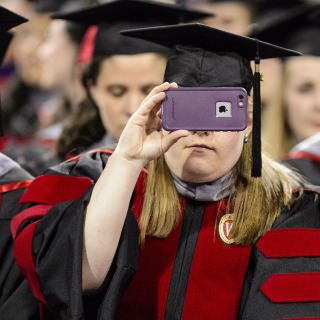 A graduate captures the moment with her cellphone camera during UW-Madison's spring commencement ceremony at the Kohl Center at the University of Wisconsin-Madison on May 12, 2017. The indoor graduation was attended by approximately 830 doctoral, MFA and medical student degree candidates, plus their guests. (Photo by Bryce Richter / UW-Madison)