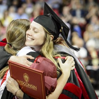 A graduate hugs her friend during UW-Madison's spring commencement ceremony at the Kohl Center at the University of Wisconsin-Madison on May 12, 2017. The indoor graduation was attended by approximately 830 doctoral, MFA and medical student degree candidates, plus their guests. (Photo by Bryce Richter / UW-Madison)