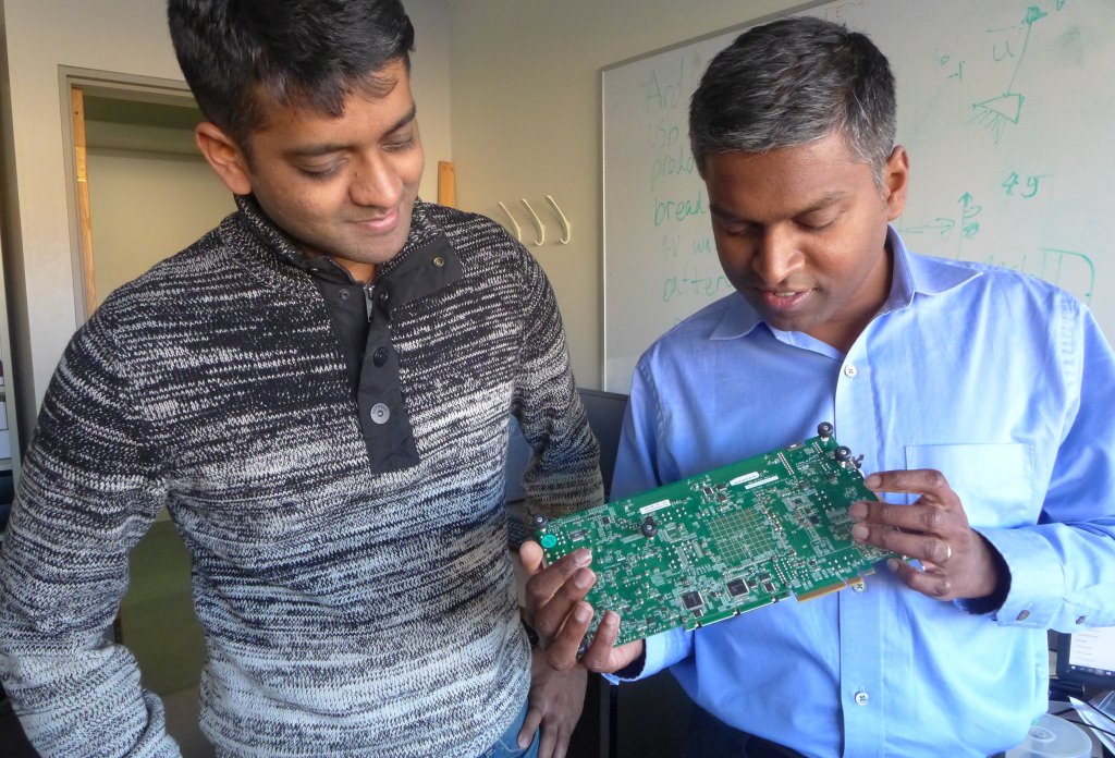 Graduate student Vijay Thiruvengadam, left, and Karu Sankaralingam, an associate professor of computer science at the University of Wisconsin–Madison, with a prototype board used to explore a new, streamlined approach specifically designed to improve performance and reduce electricity wastage at data centers. 