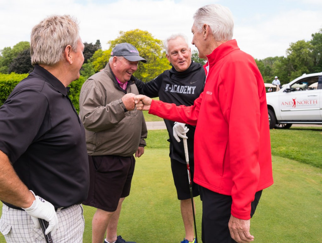 Andy North, right, exchanges knucks with Bill Buchholz as Mark Schmitz, second from right, watches.