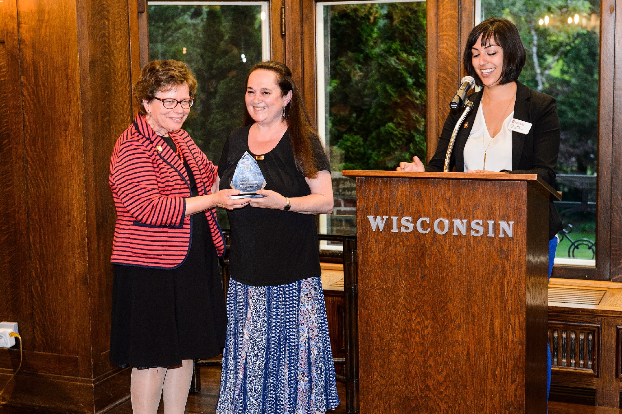 Emily Auerbach, professor of English at UW–Madison, receives the 2017 LaMarr Billups Community-University Engagement Award during a 2017 Community-University Partnership Award event at Olin House, the Chancellor's residence at the University of Wisconsin–Madison on June 28, 2017. Presenting the awards are UW–Madison Chancellor Rebecca Blank and Leslie Orrantia, UW–Madison director of community relations. (Photo by Jeff Miller / UW–Madison)