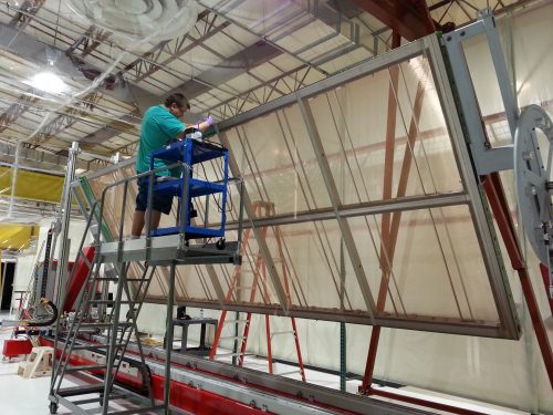 Photo: Worker soldering wire on anode panel assembly