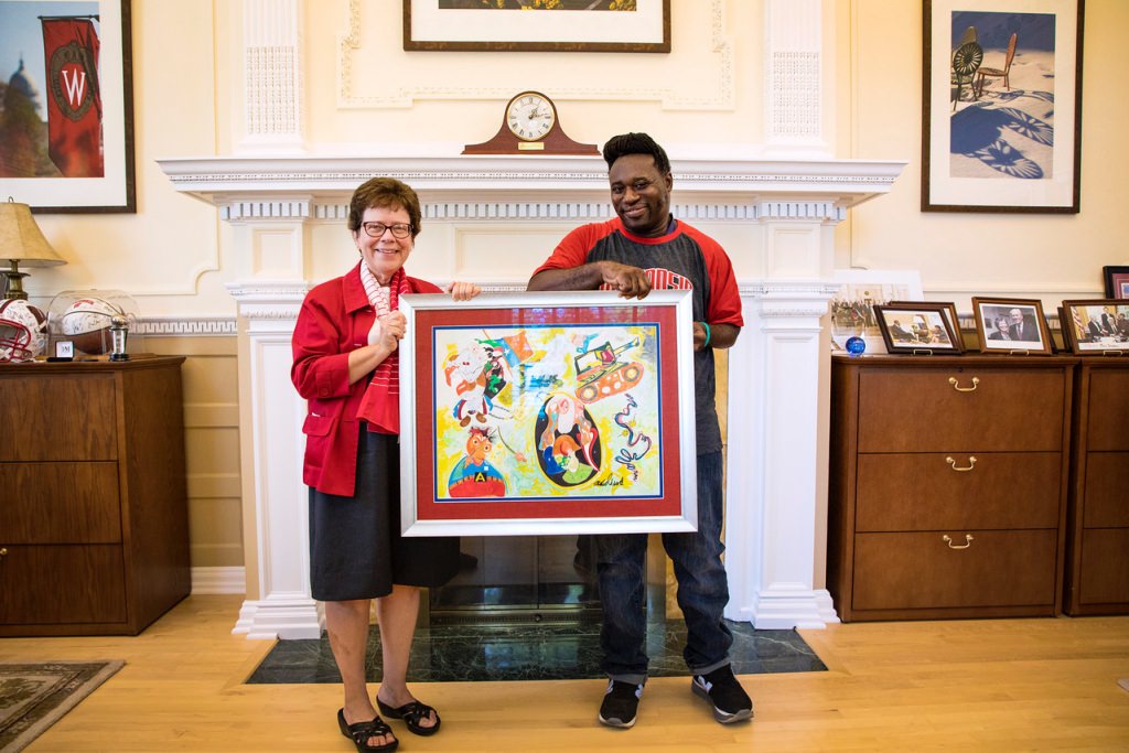 UW-Madison Chancellor Rebecca Blank poses with artist and alumnus Michael Ward and the piece he presented to UW-Madison.