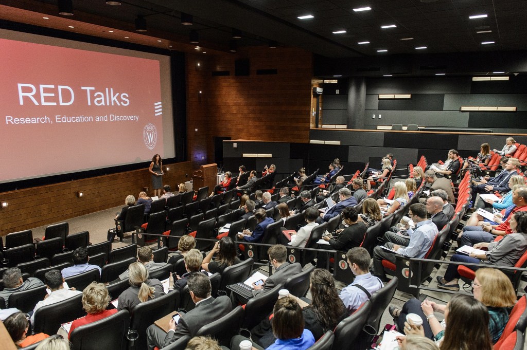 Photo: Auditorium with people watching unidentified person giving RED Talk