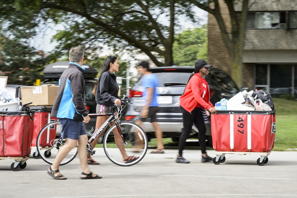 Photo: Volunteer pushing bin toward Sellery Hall