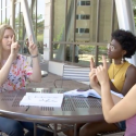 Photo: Students sitting around table learning to sign