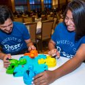 Syed Bukhari, and Kiana Gomez play a game of Hungry Hungry Hippos at the DDEEA Kick Back event.