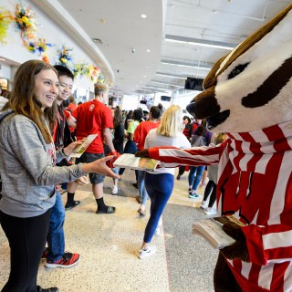 Photo: Bucky handing a book to a student