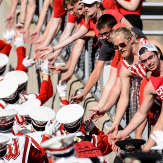 UW students give high-fives to the band as the exit the field following the fifth quarter celebration following the UW Homecoming football games versus Maryland inside Camp Randall Stadium at the University of Wisconsin-Madison on Oct. 21, 2017. The Badgers won the game 38-13. (Photo by Bryce Richter / UW-Madison)