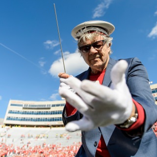 UW-Madison alum Steve Miller, of the Steve Miller Band, conducts the UW Marching Band during the fifth quarter celebration follow the UW Homecoming football games versus Maryland inside Camp Randall Stadium at the University of Wisconsin-Madison on Oct. 21, 2017. The Badgers won the game 38-13. (Photo by Bryce Richter / UW-Madison)