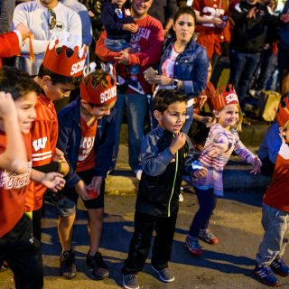 Children anxiously await the potential for receiving candy as spirited students dance and parade floats travel down State Street during the University of Wisconsin-Madison's Homecoming Parade on Oct. 20, 2017. The annual parade is one of many Homecoming week activities sponsored by the Wisconsin Alumni Association (WAA). (Photo by Jeff Miller / UW-Madison)