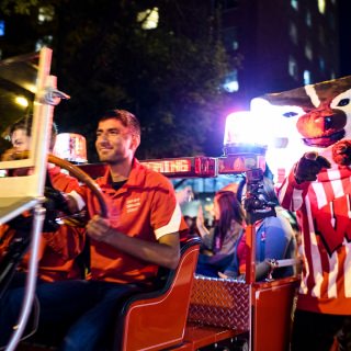 UW-Madison mascot Bucky Badger cheers as engineering student Saager Paliwal drives the the Bucky Wagon travels down State Street before hundreds of cheering spectators during the University of Wisconsin-Madison's Homecoming Parade on Oct. 20, 2017. The annual parade is one of many Homecoming week activities sponsored by the Wisconsin Alumni Association (WAA). (Photo by Jeff Miller / UW-Madison)