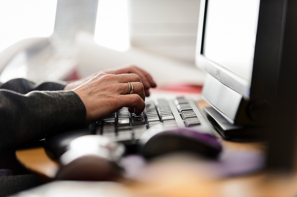 Photo: Close-up of person typing on computer keyboard