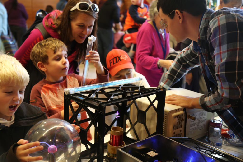 Photo: Child and parent listening to scientist