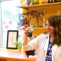 Photo: Scientist holding up a small beaker