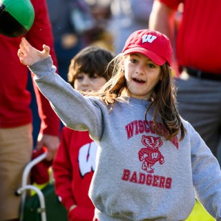 Badger fan Aubrey Hyland, 9, tosses a football during a Badgerville tailgate event at Engineering Mall at the University of Wisconsin-Madison, ahead of the Wisconsin Badgers homecoming football game against the Maryland Terrapins at Camp Randall Stadium on Oct. 21, 2017. (Photo by Jeff Miller/UW-Madison)