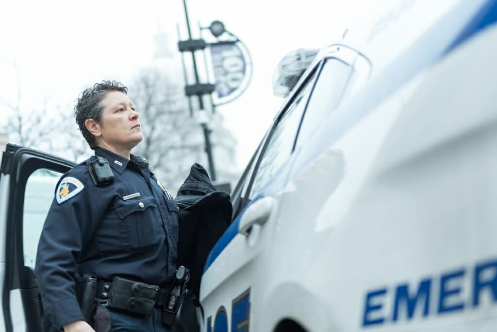 Photo: Tammi Droessler standing next to squad car