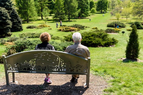 Photo: Couple sitting on bench looking at Longnecker Gardens