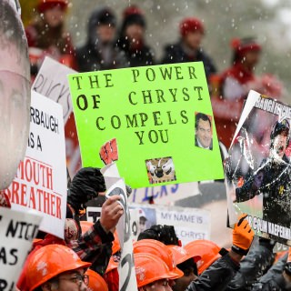 Photo of fan holding sign.