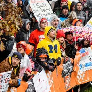 Photo of a Michigan fan with Badger fans.