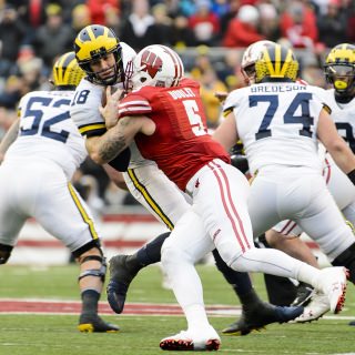 Photo of Badgers outside linebacker Garrett Dooley (5), sacking Michigan quarterback Brandon Peters (18).