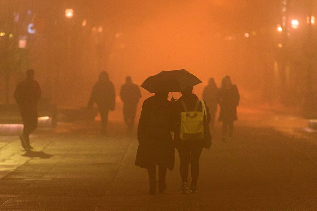 Photo: People under umbrella walking in fog