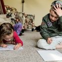 Photo of two siblings coloring.