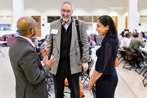 Photo of Washington University researcher David Gutmann, center, speaking with UW–Madison's Dhanu Shanmuganayagam, left, and Neha Patel.