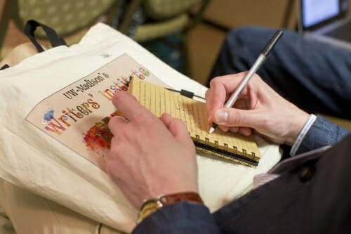 Photo: Closeup of a person's hand writing in a notebook