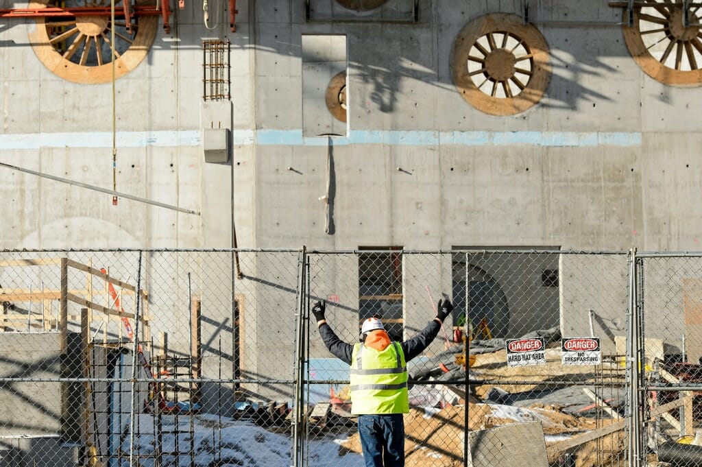 Photo: Worker in hardhat with arms raised