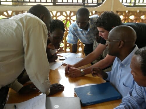 Photo: American trainer showing test to Uganda staff gathered around a table