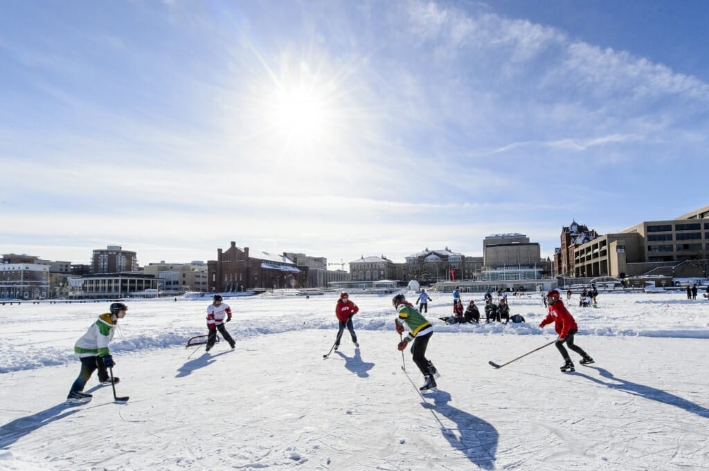 Photo of students facing off during the pond hockey tournament on Lake Mendota.