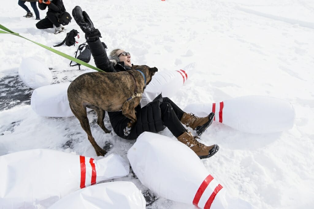 Photo of Carley Varo and her dog Moose tumbling amid the bowling pins.