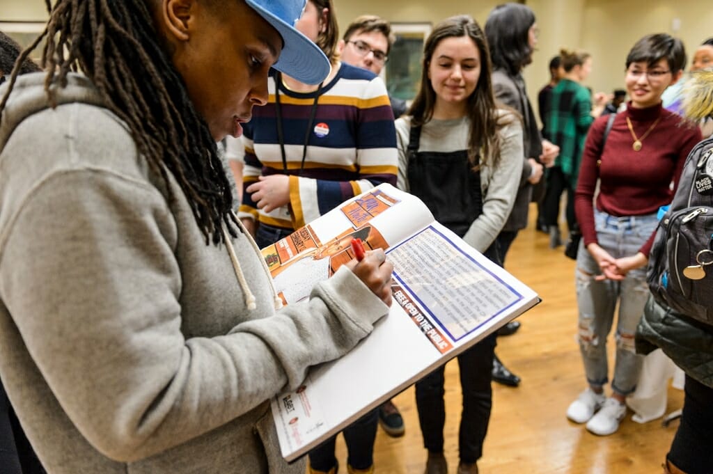 Waithe signs a guest book for the Wisconsin Union Directorate's Distinguished Lecture Series committee during a meet-and-greet session with students.