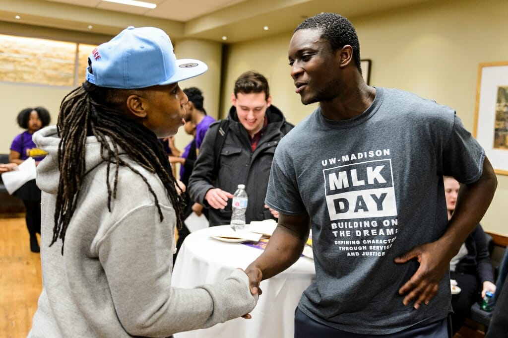 Lena Waithe shakes hands with a man during an event reception