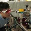 Materials science and engineering postdoctoral researcher Hyungwoo Lee looks inside a thin film deposition system during oxide thin film structure growth. 