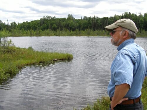 Photo: Steve Carpenter stands on a berm between Peter and Paul lakes at the University of Notre Dame Environmental Research Center. At the time, the study lakes were being used for a study of early warning indicators of harmful algae blooms.