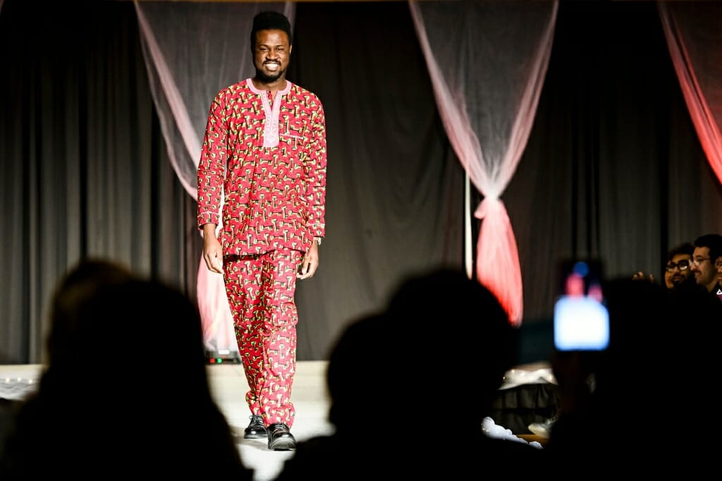 Student Ayomide Awosika wears a red buba and sokoto, a traditional shirt and pants for the Yoruba people of Nigeria and other parts of west Africa.