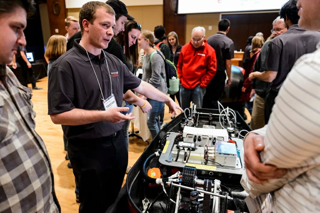 UW-Madison Badgerloop battery team lead Tristan Steiner, left, explains the pod to guests.