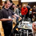 UW-Madison Badgerloop battery team lead Tristan Steiner, left, explains the pod to guests.