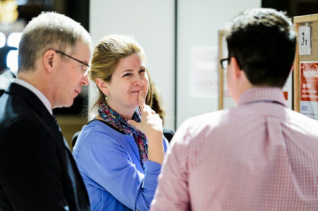 Steven Cramer, UW-Madison vice provost for teaching and learning, and Michelle Harris, faculty associate in the Biology Core Curriculum, listen to Evan Hernandez talk about his research project.