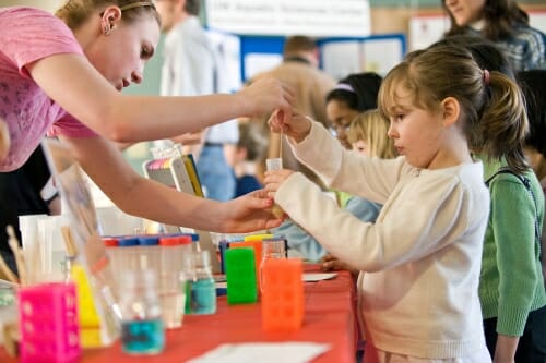 Photo: Unidentified student giving young girl a DNA sample