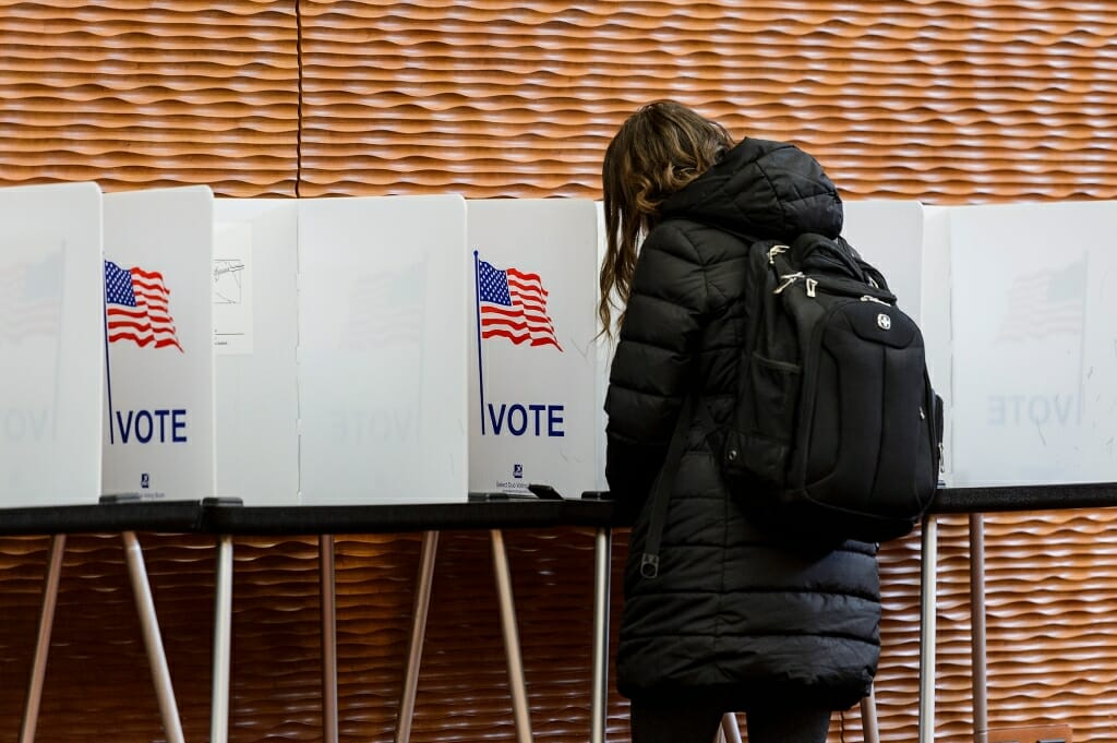 A woman fills out an election ballot for the spring election and register her votes at the Gordon Dining and Event Center 