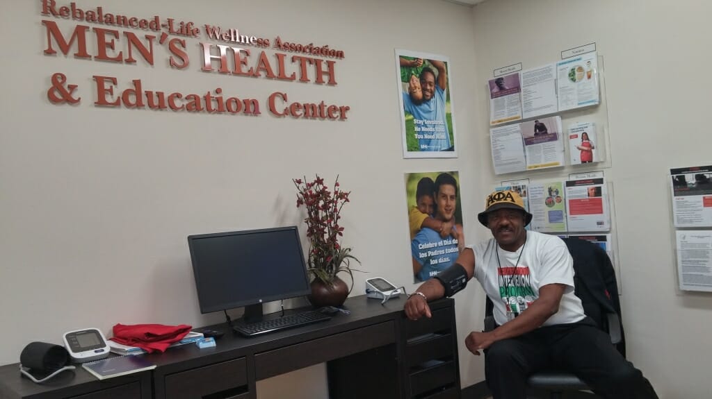 Photo of a male client having his blood pressure checked.