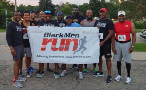 Photo of Black Men Run members posing with banner.