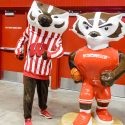 UW mascot Bucky Badger stands next to a Bucky statue, titled 