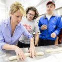 Michelle Clasen (left), of Clasen's Bakery, demonstrates how to roll bread dough to students during a Fermented Food and Beverage class taught by Nick Smith.