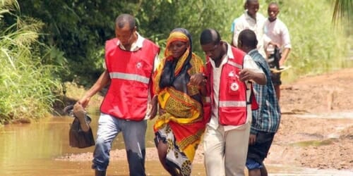 Photo: People being led from flooded areas by emergency workers