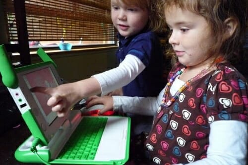 Photo: 2 young girls working at a green laptop computer